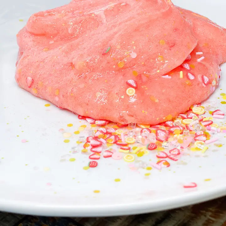 showing the slime which is pink with lemons and strawberry clay on a plate